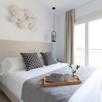 Double bedroom with decor combining blue tones and sandy colours, creating a very bright atmosphere.