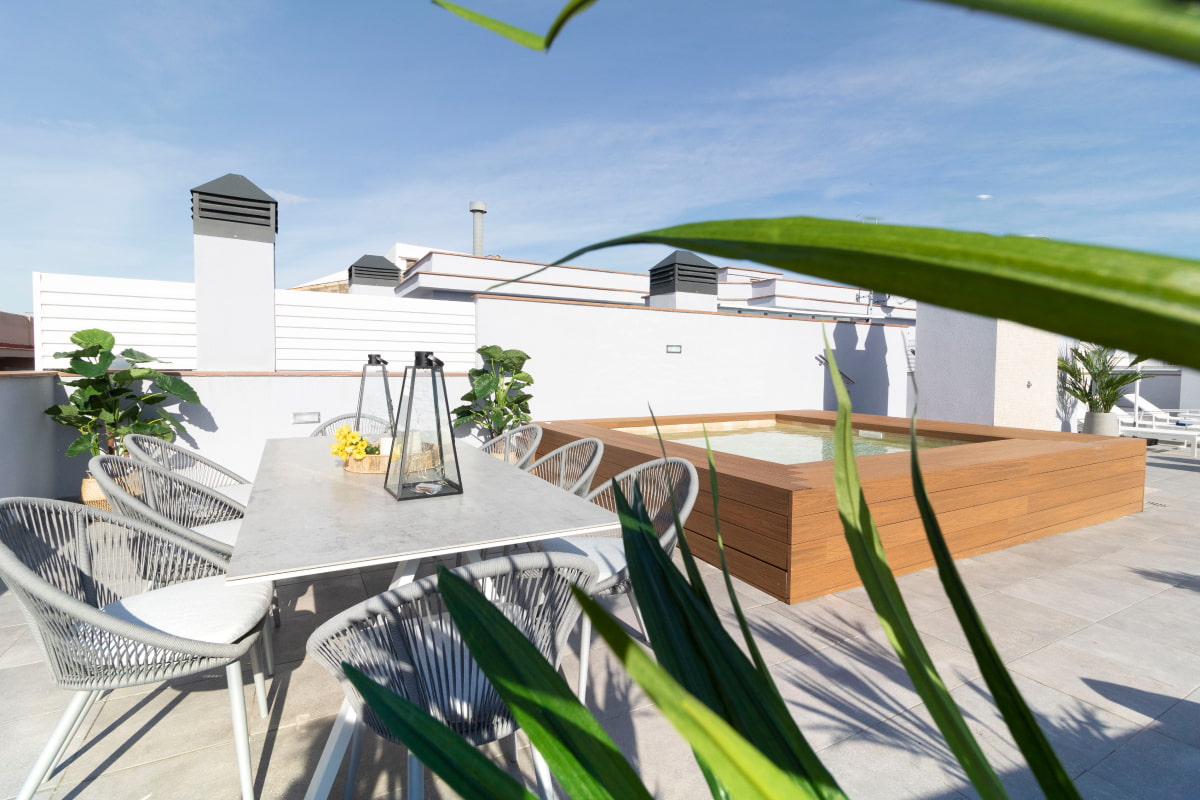 Upper terrace with a table and chairs next to the jacuzzi pool, perfect for moments of relaxation and socialising.