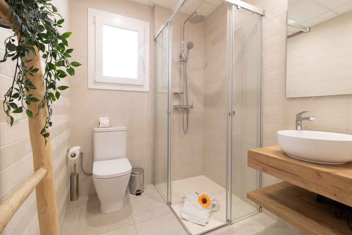 Bathroom equipped with WC, countertop washbasin, and shower with a glass screen, featuring a practical and tidy design.