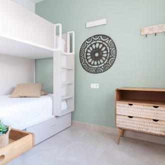 One of our bedrooms with modern bunk beds, white sheets, and a mint-coloured wall.