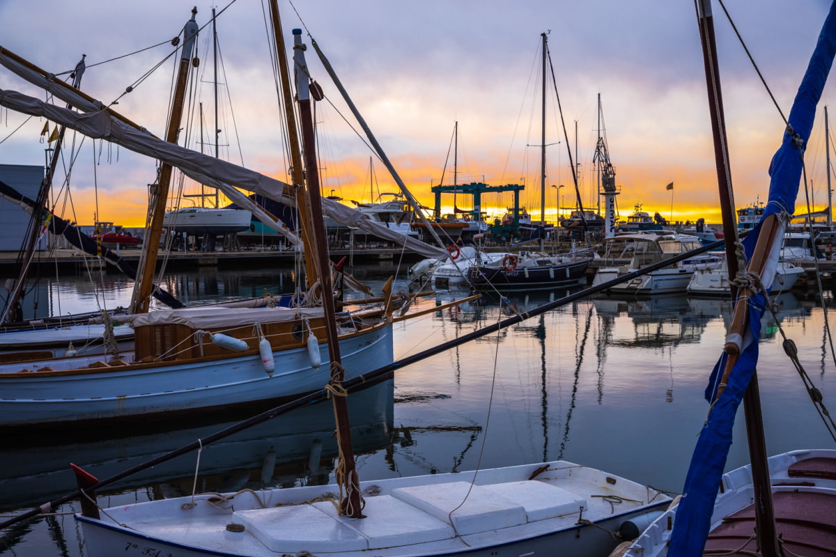 Boats docked at the pier, reflecting the calm of the water.