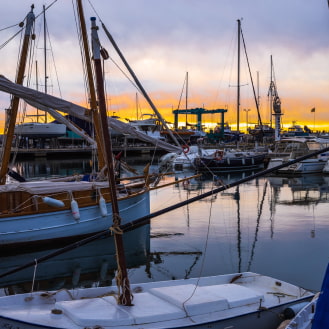 Boats docked at the pier, reflecting the calm of the water.