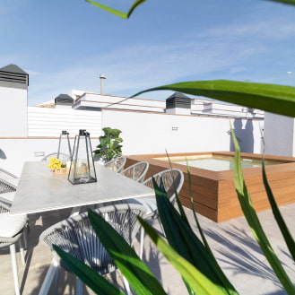 Upper terrace with a table and chairs next to the jacuzzi pool, perfect for moments of relaxation and socialising.