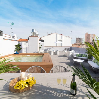 General view of the rooftop at Calafell Home Apartments: tables and chairs, jacuzzi pool, and chill-out area.