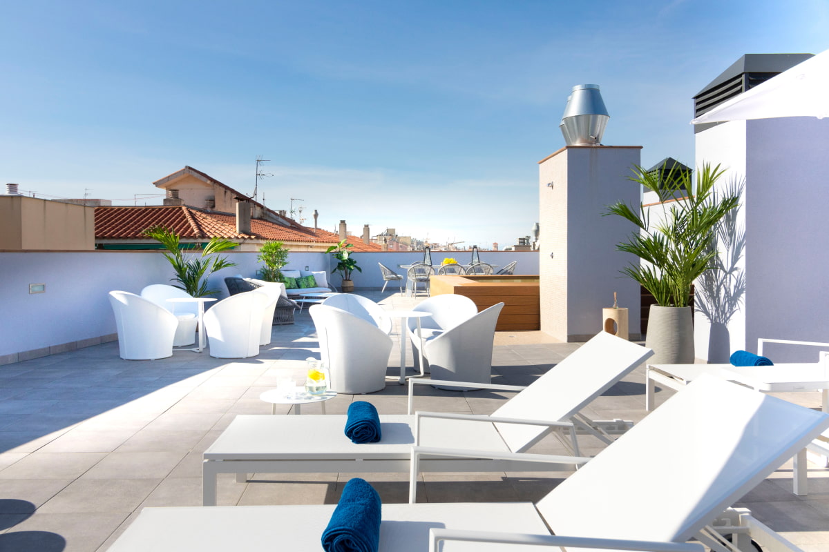 General view of the solarium area at Calafell Home Apartments, with the jacuzzi in the background.