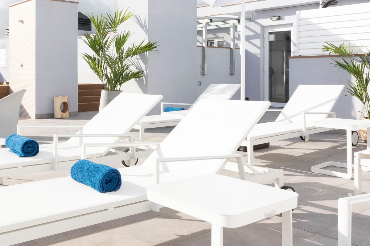 Close-up of the white sun loungers in our solarium.